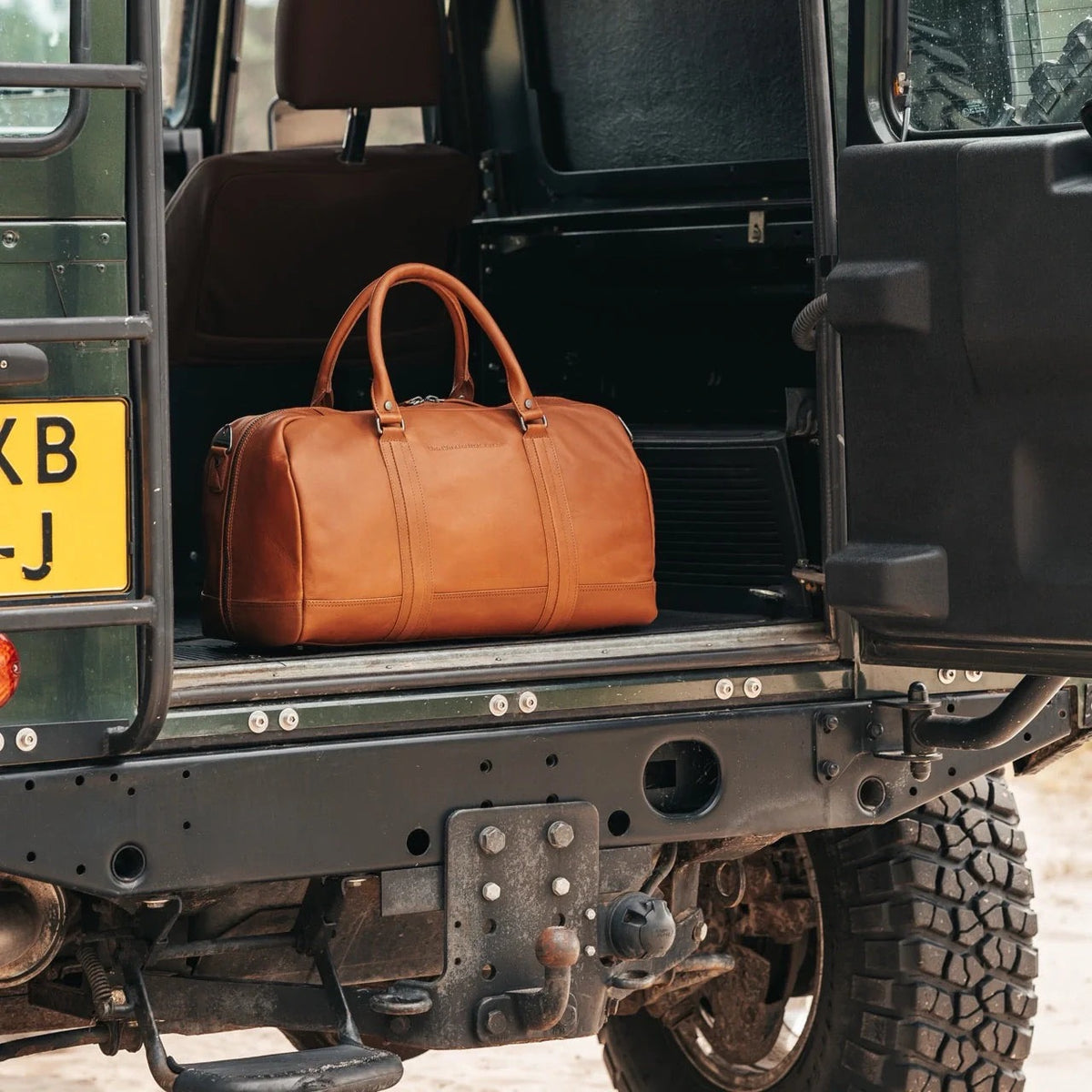 Chesterfield Perth Cognac im Kofferraum eines Land Rover Defenders – Lifestyle-Aufnahme Reise