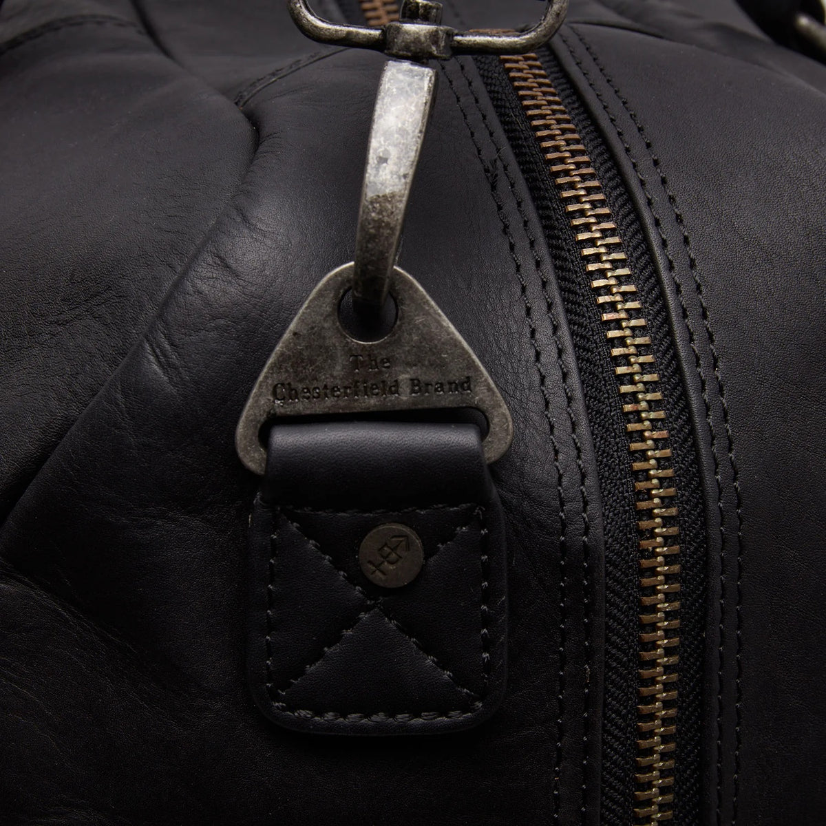 Chesterfield Perth Schwarz – Detailansicht Metall-Logo-Anhänger am Reißverschluss, Nahaufnahme Zipper